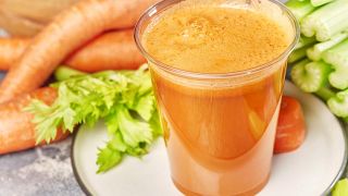Изображение стакана сока моркови, сельдерея и петрушки.